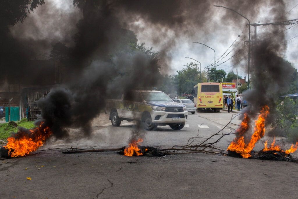 Una camioneta de la policía en un corte con gomas prendidas fuego Yerba Buena Tucuman